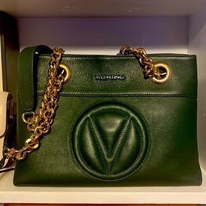 This is a Forrest green Valentino bag that was gently used. It is pure leather.